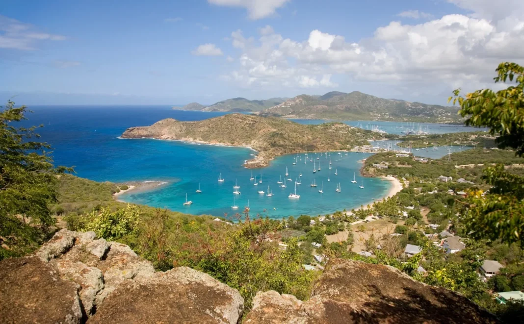 Vista aérea de una playa de arena blanca y aguas turquesas en Antigua y Barbuda.