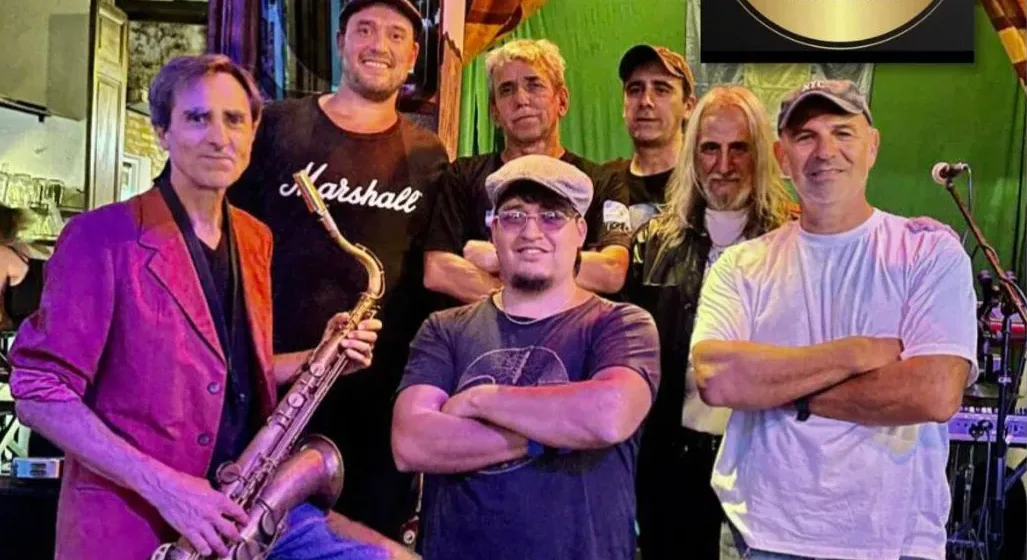 Público disfrutando de un concierto de blues en el patio de un club de barrio.