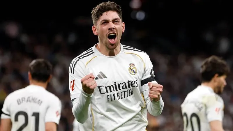 Ilustración del trofeo de la UEFA Champions League junto a un balón de fútbol sobre el césped.