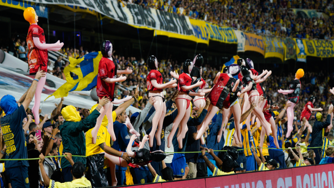 Niños jugando al fútbol en una cancha de inferiores de Rosario Central