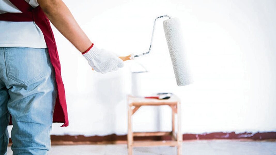 Lata de pintura y pincel sobre una superficie, con símbolo de advertencia de toxicidad