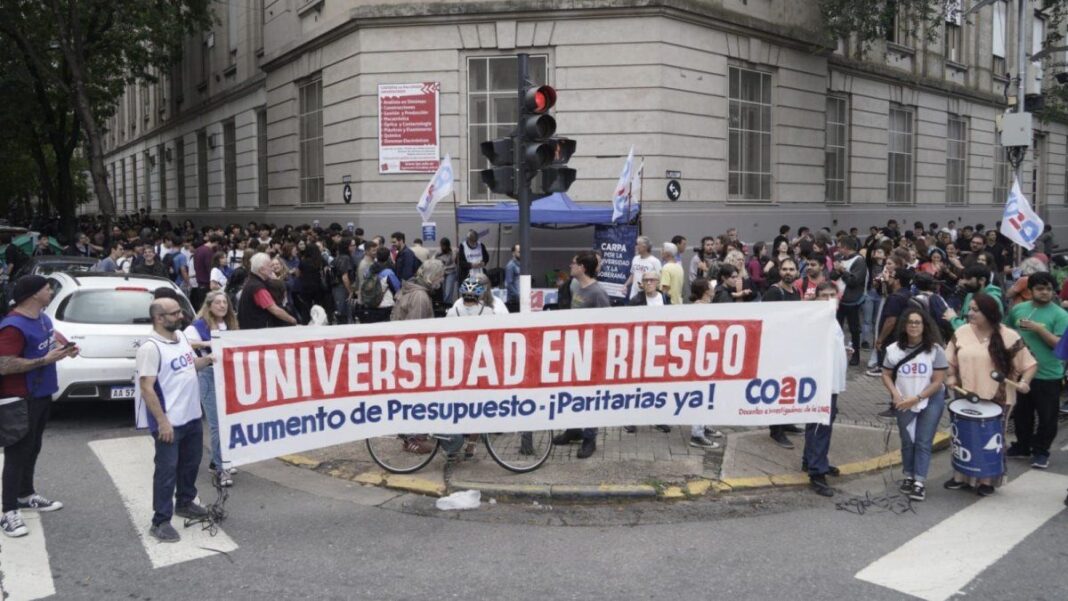 Docentes y participantes durante el abrazo simbólico en la Facultad de Ciencias Exactas de la UNR, en avenida Pellegrini.