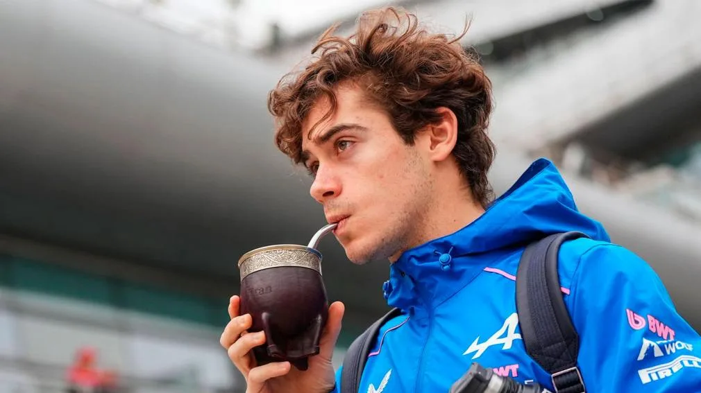 Franco Colapinto junto a un auto de Fórmula 1 en un circuito urbano.