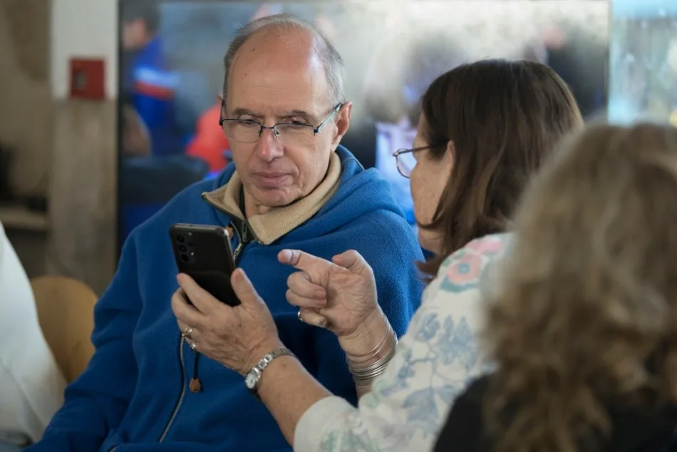 Persona mayor utilizando un teléfono celular en un taller de la Municipalidad de Rosario