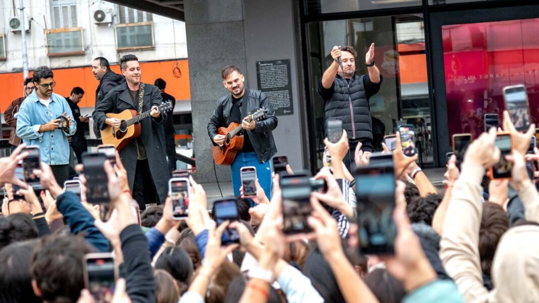 Público reunido bajo paraguas durante el show sorpresa de Tan Biónica en la explanada del Centro Cultural Fontanarrosa, Rosario.