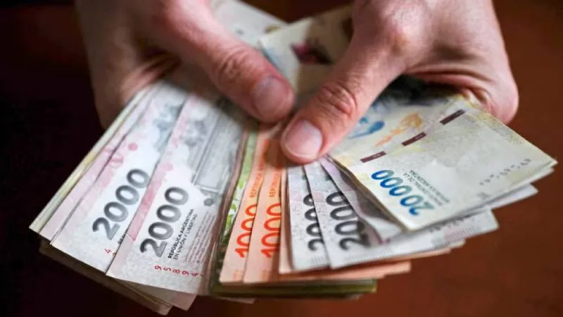 Calculadora y billetes de peso argentino representando el cálculo del aguinaldo en Santa Fe